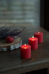 three red candles in a wooden interior