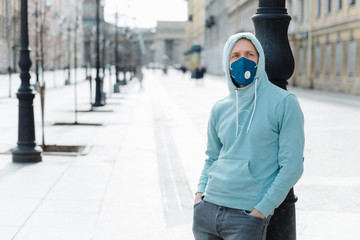 Pandemic coronavirus, Covid-19. Serious young man dressed in sweatshirt and jeans, wears...