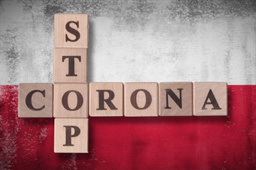 Fototapeta na wymiar Flag of Poland with wooden cubes spelling STOP CORONA on it. 2019 - 2020 Novel Coronavirus (2019-nCoV) concept art, for an outbreak occurs in Poland.