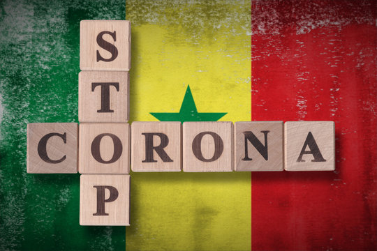 Flag of Senegal with wooden cubes spelling STOP CORONA on it. 2019 - 2020 Novel Coronavirus (2019-nCoV) concept art, for an outbreak occurs in Senegal.