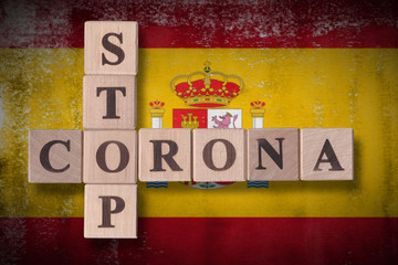 Flag of Spain with wooden cubes spelling STOP CORONA on it. 2019 - 2020 Novel Coronavirus (2019-nCoV) concept art, for an outbreak occurs in Spain.