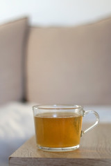 Cup of herbal tea on a living room table. Selective focus.