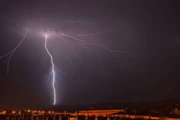 un rayo cae sobre una ciudad durante una noche de tormenta 