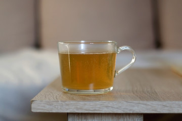 Cup of herbal tea on a living room table. Selective focus.