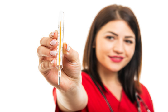 Selective focus of beautiful young cardiologist showing thermometer