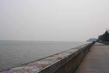 Obraz premium concrete fence on the pier embankment sea separates the water from the shore on the horizon