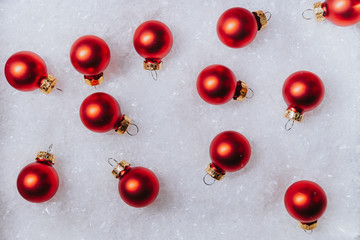 Christmas composition. Red bubbles lying on the snow. Merry Christmas and Happy New Year, flat lay top shot