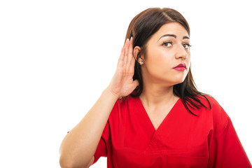 Portrait of doctor wearing scrubs making can't hear gesture