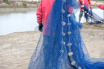 Pescadores manipulando red de pesca para pescar en rio