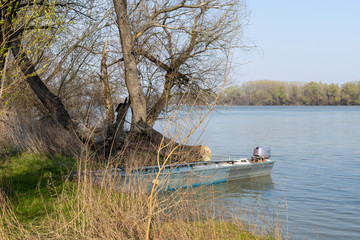 Fototapeta na wymiar Fishing Boat On The River Bank On A Sunny Day