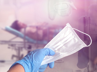 Fototapeta premium Hand holding the hygienic mask,blurred Elderly patients in hospital emergency rooms,with lens flare,selective focus.Prevents coronavirus concept.