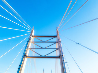 Pylons with steel ropes of the cable-stayed bridge agains clear blue sky. Detail of the multi-span bridge in Saint Petersburg, Russia. 