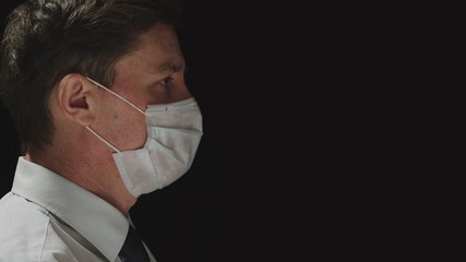 CORONAVIRUS: Side view of adult male put on a mask