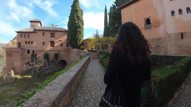 Tourist walking through the monumental complex of the Alhambra. Granada, Andalusia, Spain.