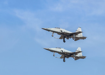 Two fighter jet military aircrafts flying showed with high speed on blue sky 