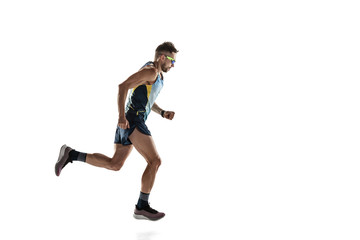 Triathlon male athlete running isolated on white studio background. Caucasian fit jogger, triathlete training wearing sports equipment. Concept of healthy lifestyle, sport, action, motion. Side view.