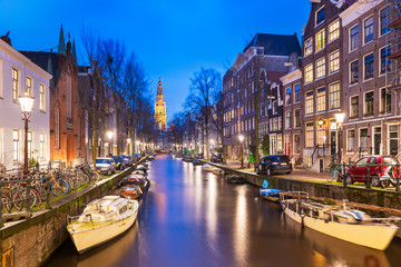 Amsterdam, Netherlands canals and church tower at dusk.