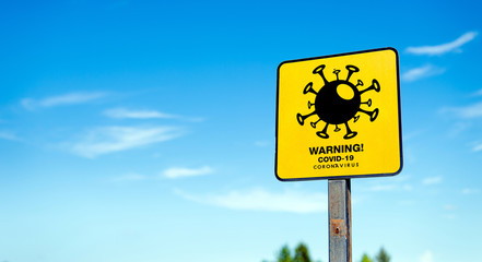 closeup warning covid-19 sign with a blue sky background