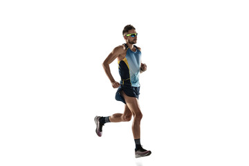 Triathlon male athlete running isolated on white studio background. Caucasian fit jogger, triathlete training wearing sports equipment. Concept of healthy lifestyle, sport, action, motion. Side view. - obrazy, fototapety, plakaty