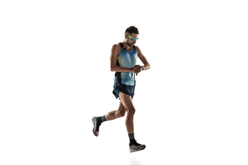 Triathlon male athlete running isolated on white studio background. Caucasian fit jogger, triathlete training wearing sports equipment. Concept of healthy lifestyle, sport, action, motion. Time check.