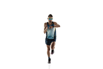 Triathlon male athlete running isolated on white studio background. Caucasian fit jogger,...