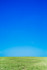 Fototapeta na wymiar 雲一つない青空と緑の丘。背景用素材