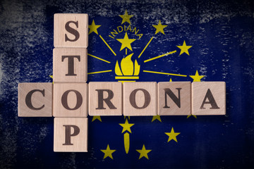 Flag of the state of Indiana with wooden cubes spelling STOP CORONA on it. 2019 - 2020 Novel Coronavirus (2019-nCoV) concept art, for an outbreak occurs in Indiana, US.