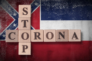 Flag of the state of Mississippi with wooden cubes spelling STOP CORONA on it. 2019 - 2020 Novel Coronavirus (2019-nCoV) concept art, for an outbreak occurs in Mississippi, US.