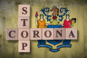 Flag of the state of New Jersey with wooden cubes spelling STOP CORONA on it. 2019 - 2020 Novel Coronavirus (2019-nCoV) concept art, for an outbreak occurs in New Jersey, US.