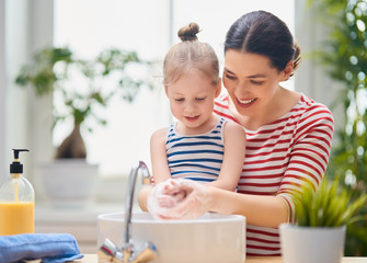 girl and her mother are washing hands