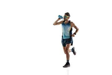 Triathlon male athlete running isolated on white studio background. Caucasian fit jogger, triathlete training wearing sports equipment. Concept of healthy lifestyle, sport, action, motion. Drinks