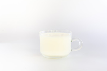 milk in clear cup on white background.