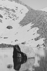 Gran paradiso big stone in a mountain lake black and white 