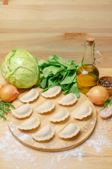 Fototapeta na wymiar Dumplings on a wooden board with vegetables