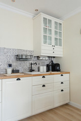 Fototapeta na wymiar Cozy, bright Scandinavian-style kitchen. White, gray, black. Dishwashing sink, faucet, metal dishwasher, tile with patterns.