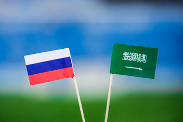 National flag of Russia and Saudi Arabia on Football pitch. Football ball on green grass