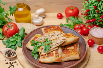 Crepes on a wooden board with meat