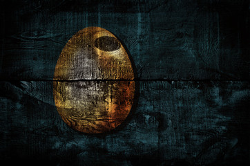 Obraz na płótnie Canvas Golden easter egg shape on old wooden boards. Dark grunge background with wooden texture. Happy easter creative greeting card design. Golden wood texture. Background for poster, banner