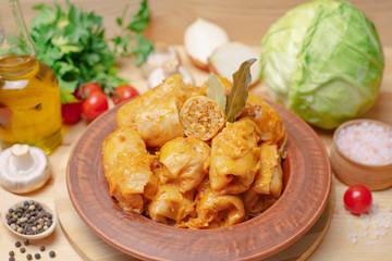 Cabbage rolls on a wooden board with vegetables