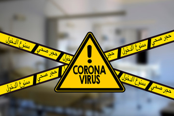 Road sign indicating coronavirus, arabic text meaning no entry and quarantine with blur hospital...