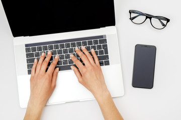Home office workspace mockup. Laptop with blank screen, hands and accessories on white