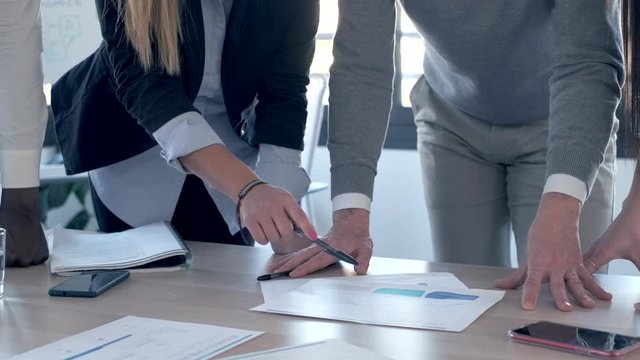 Video of close-up view of the hands of business people pointing at the statistics of the company in the office.
