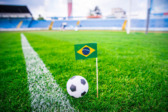 Brazil national Flag and football ball on green grass. Fans, support photo, edit space