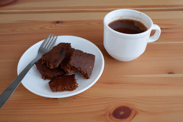 Brownie cake with a Cup of cocoa, on a wooden background
