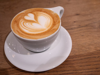 A coffee with a beautiful latte art heart on top