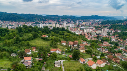 Fototapeta na wymiar Aerial view of downtown Tuzla at sunset, Bosnia. City photographed by drone, traffic and objects , landscape.city photographed from air by drone.Old balkan buildings and communism type of architecture