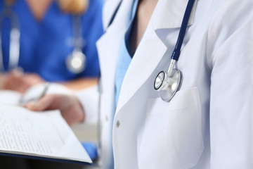 Stethoscope head lying on doctor chest wearing blue uniform closeup. Physical exam, patient...