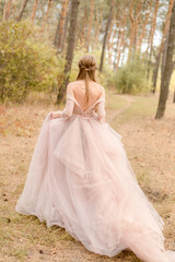 Fototapeta premium bride in pink dress walking in forest