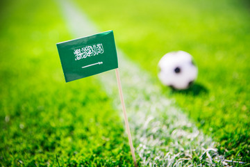 Saudi Arabia national Flag and football ball on green grass. Fans, support photo, edit space