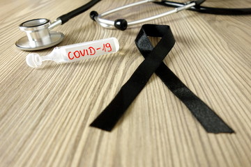 Mourning ribbon, ampoule with text Covid-19 and stethoscope. Coronavirus death victim concept